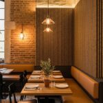 Warm-toned restaurant interior with Slatstone Martian stone wall panels behind leather banquettes, featuring acoustic felt backing and ambient lighting.